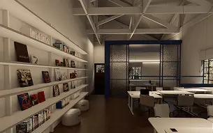 Vista interna de sala de trabalho. Estantes com livros ocupam a parede à esquerda.